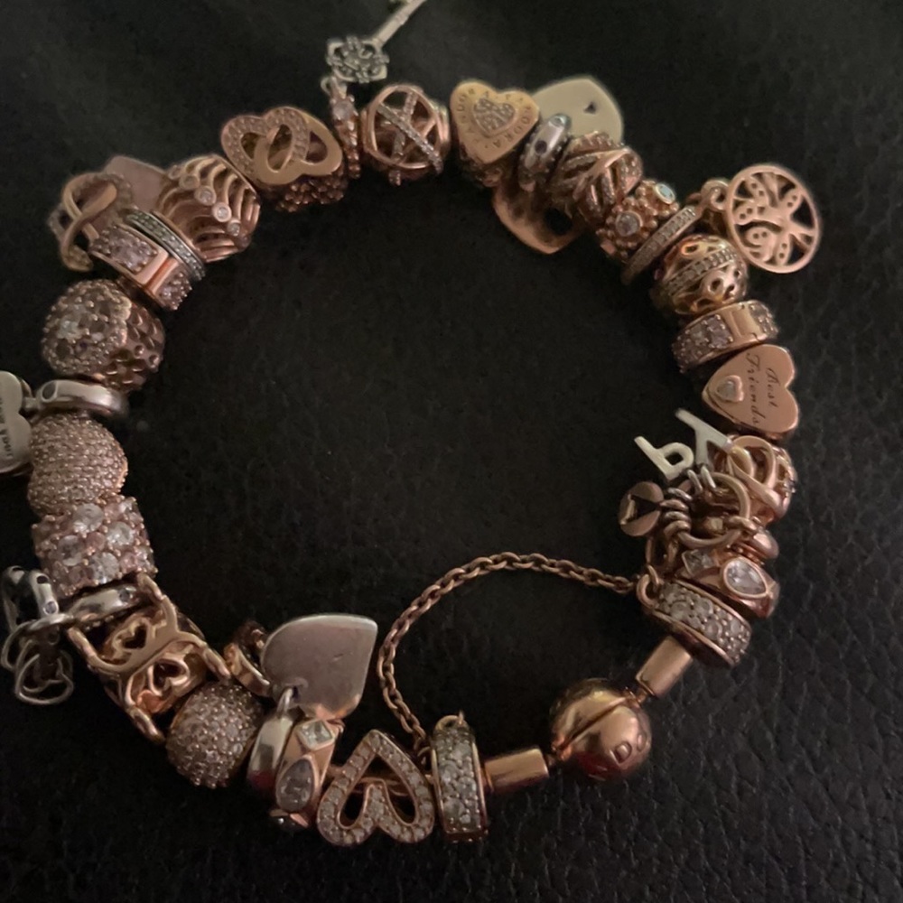 Pandora rose gold bangle with 27 rose pandora charms and 1 safety chain